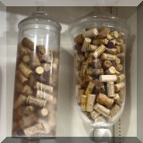 D17. 2 Tall glass jars filled with corks. 